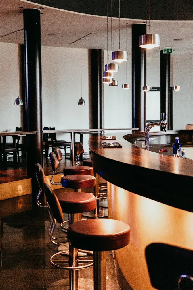 Bar-Bereich mit Holztresen und Barhockern in der Eventlocation Wesseling